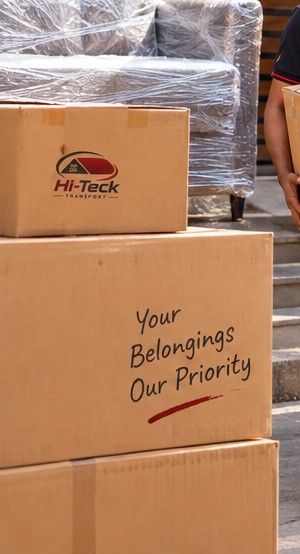 Stacked, labelled moving boxes reading Your Belongings, Our Priority